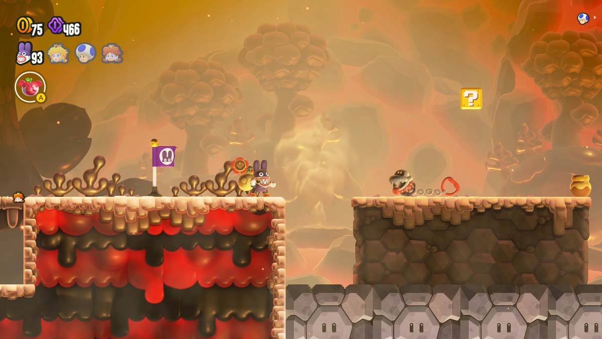 スーパー マリオ ブラザーズのゲームで、キャラクターが溶岩の穴を飛び越えようとしている、燃えるような風景