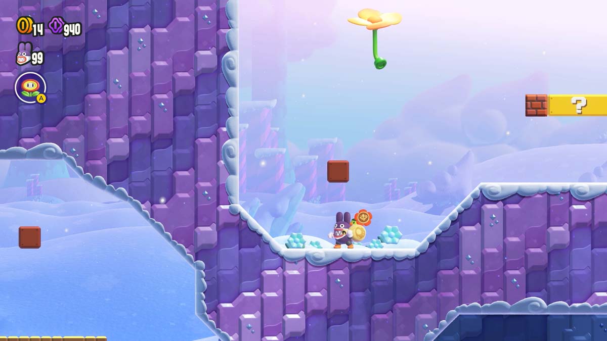 「スーパー マリオ ブラザーズ ワンダー」のゲームプレイ スクリーンショット。雪の丘の上に紫色の衣装を着たキャラクターがコイン カウントやその他の HUD 要素とともに表示されています。