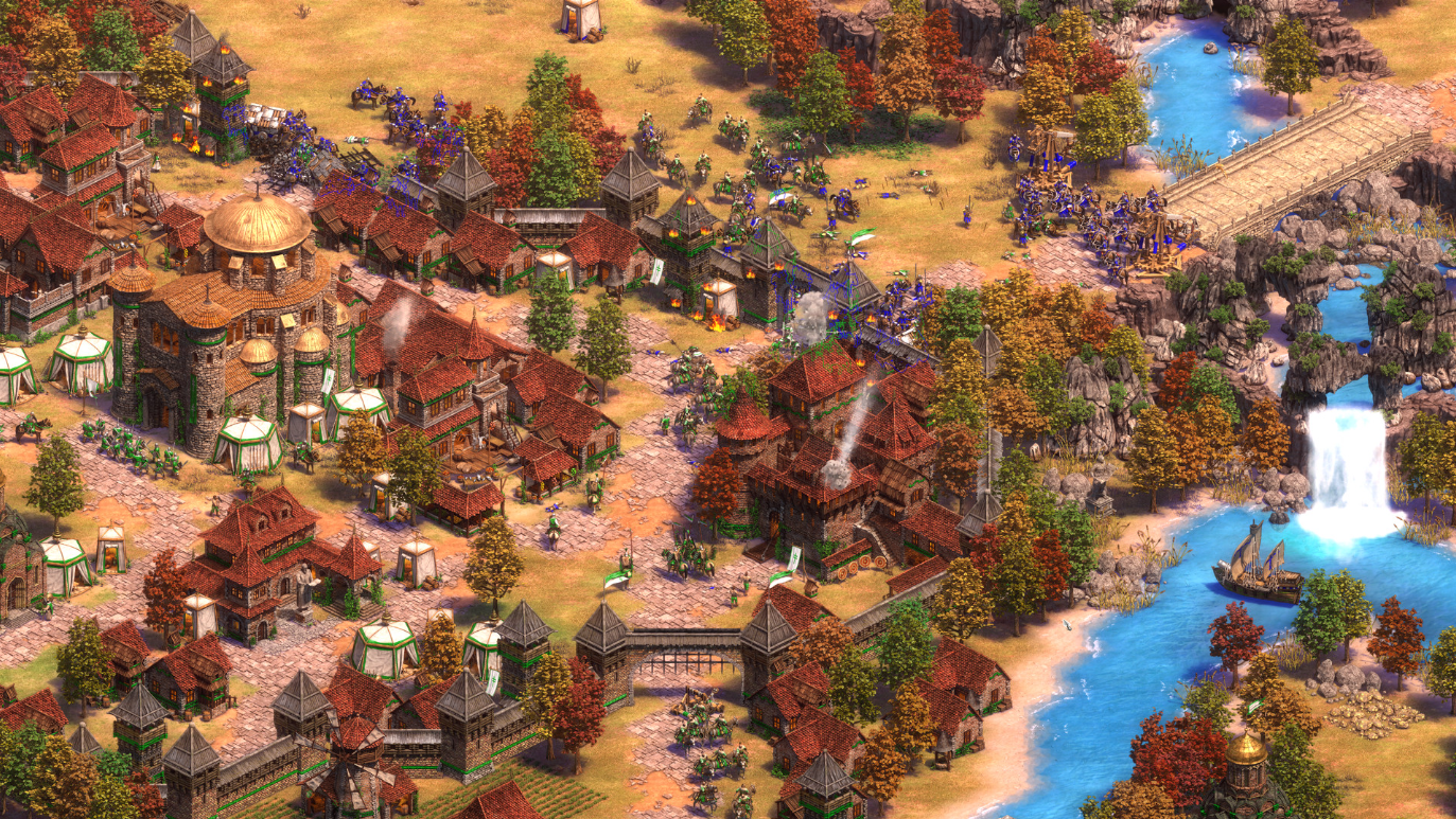 RTS ゲーム Age of Empires II: Definitive Edition のスクリーンショット。紅葉の中に城と軍隊のある城壁都市が示されています。