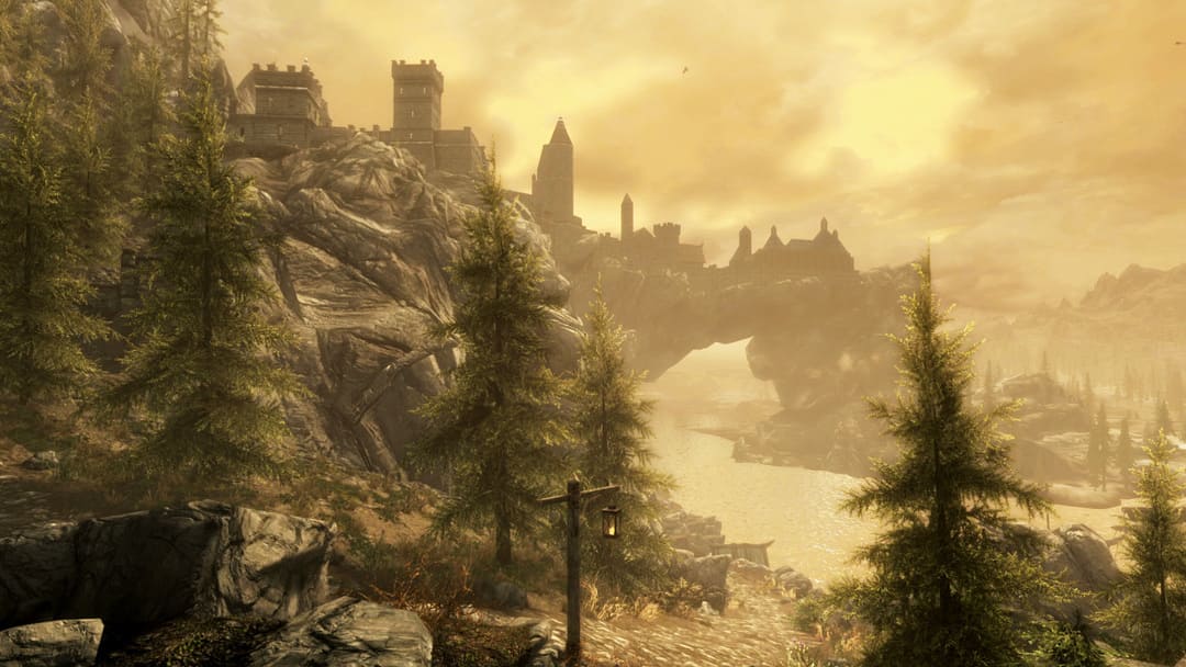 Elder Scrolls v Skyrimのスクリーンショットは、ヘイズの川の上のアーチの上に要塞の構築を示すSkyrim