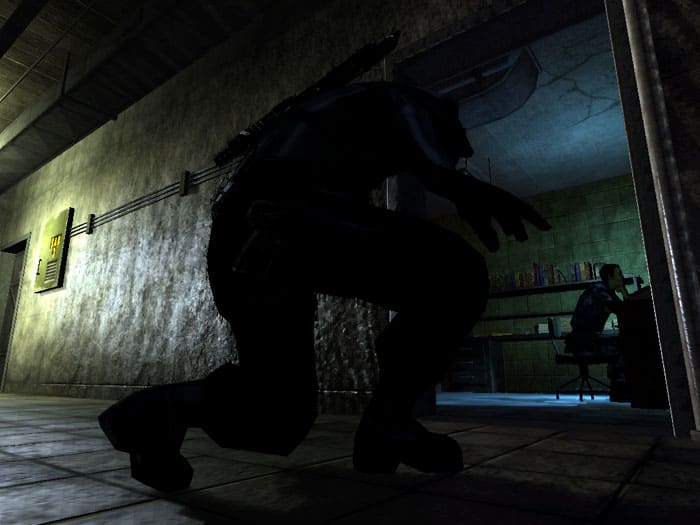 ゲームのスクリーンショットTom ClancyのSplinter Cell Chaos理論は、机にいる男と一緒に部屋に忍び込んでいる男を示しています。