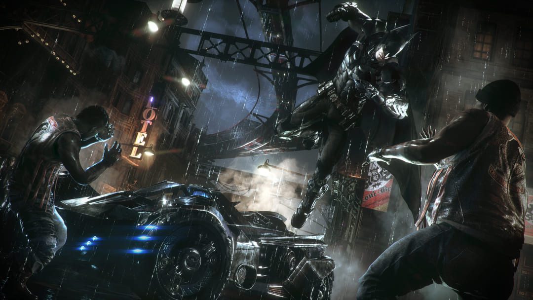 ゲームのスクリーンショットバットマン：バットマンが誰かをパンチしようとしていることを示すアーカムナイト、バックモービルはバックグラウンドにあります