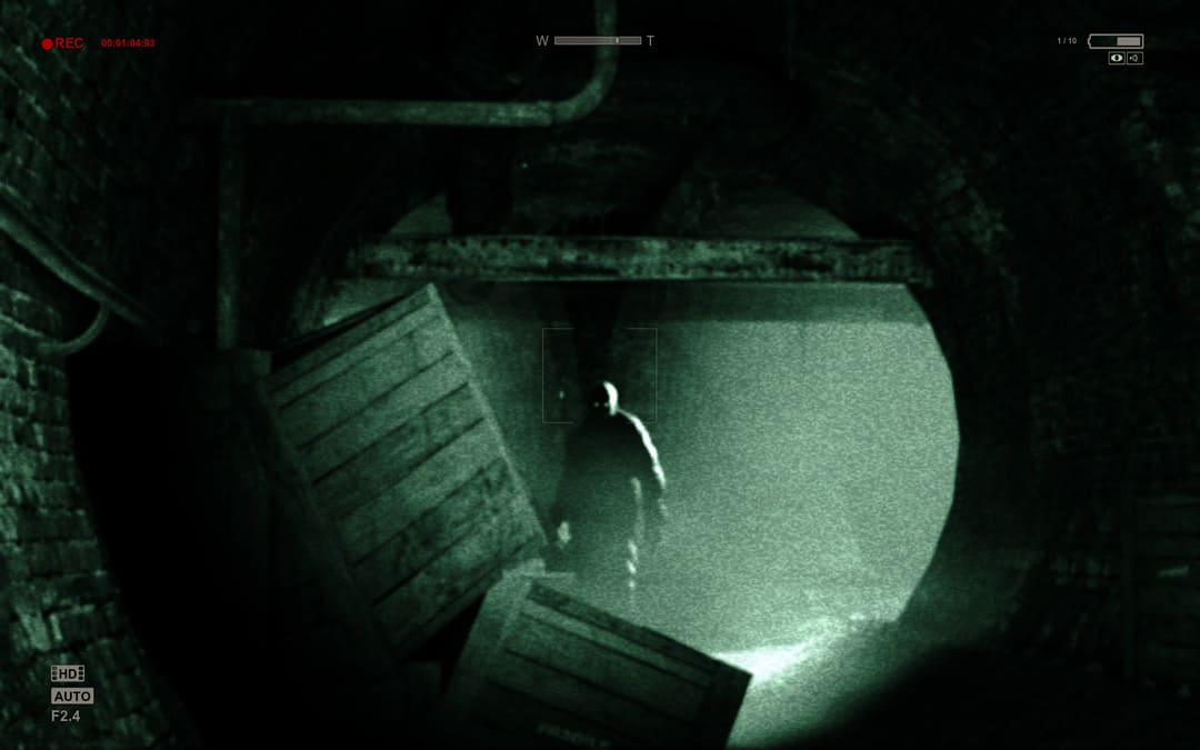 ゲームOutlast（2013）のスクリーンショットは、カムコーダーを通って暗い放棄されたトンネルで見られる数字を示しています
